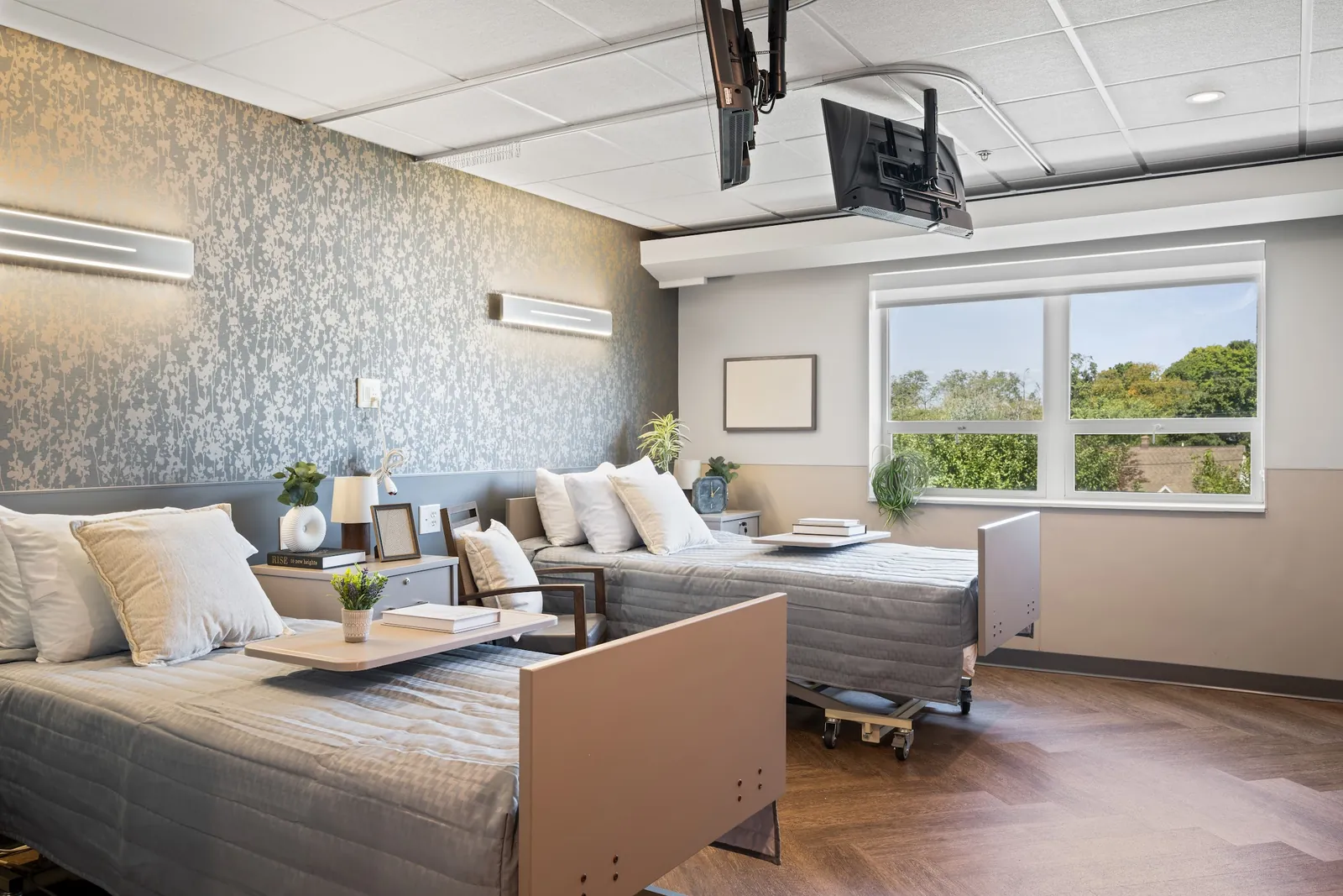 Newly renovated resident room with two made beds and herringbone floors