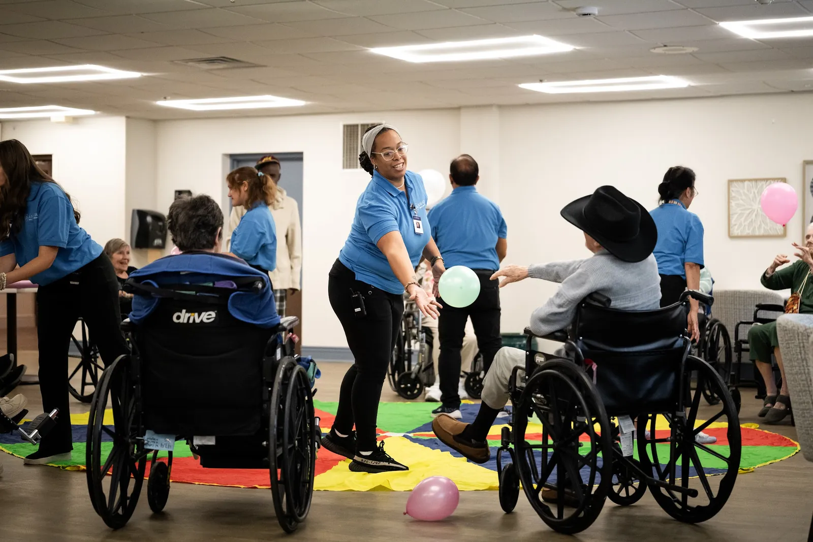 Amara recreation team leading a balloon game with residents in the dayroom