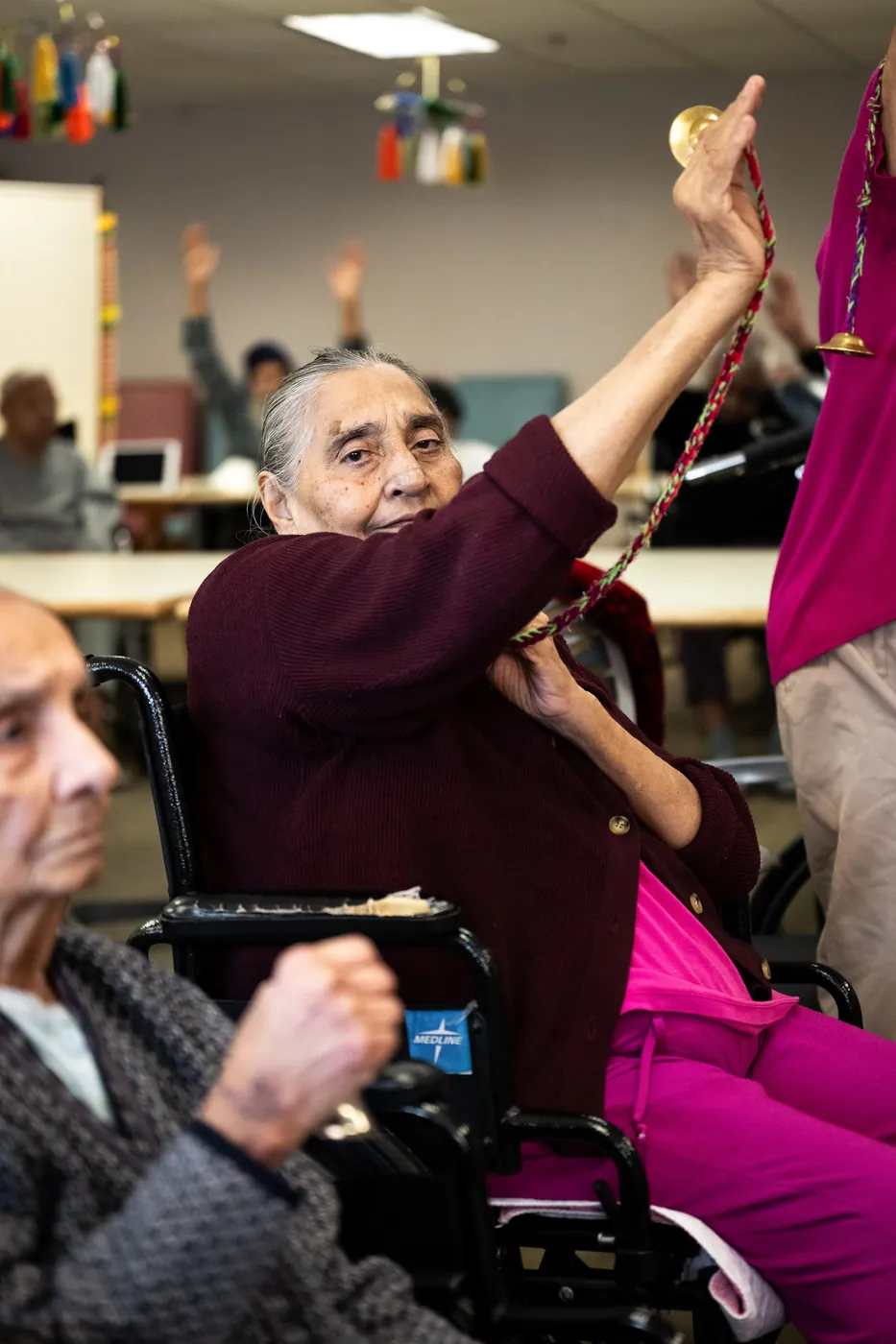 Resident smiling while playing hand bells during an activity