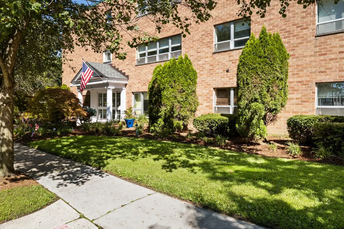 Amara Rehab and Nursing building exterior with landscaped lawn and American flag