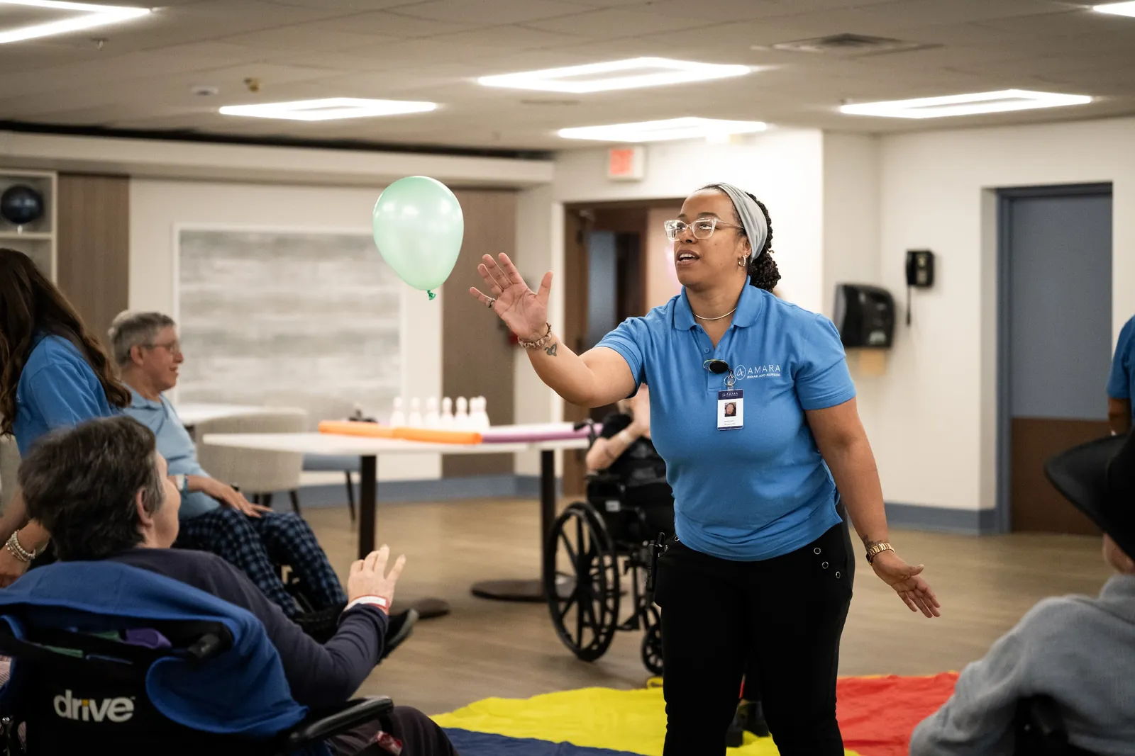 Amara team member leading a balloon activity with residents in the dayroom